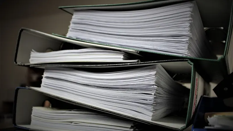 Archivadores repletos de hojas apilados unos sobre otros